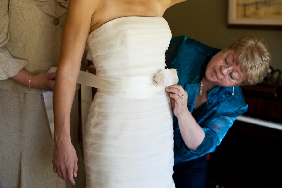 a bride gets a belt wrapped around her waist