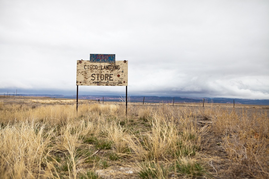 a barren landscape on a stormy with a sign in the foreground