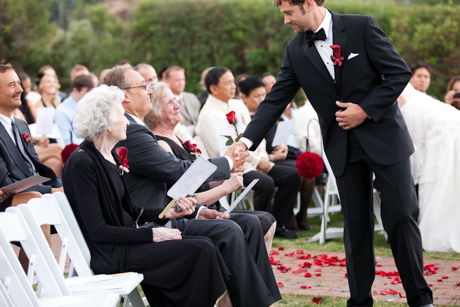 a groom shakes his father's hand during a wedding ceremony