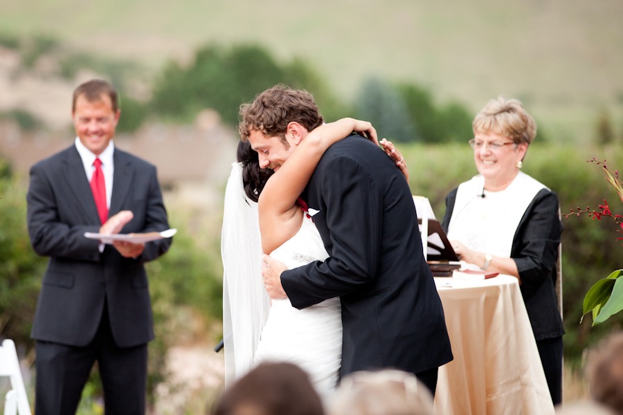 a bride and groom hug during an outdoor wedding ceremony