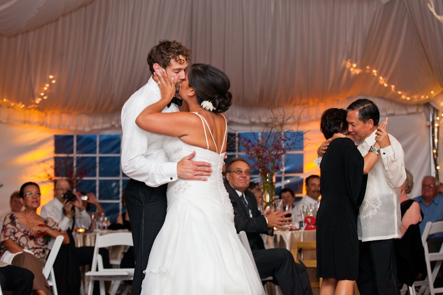 a bride and groom kiss while dancing