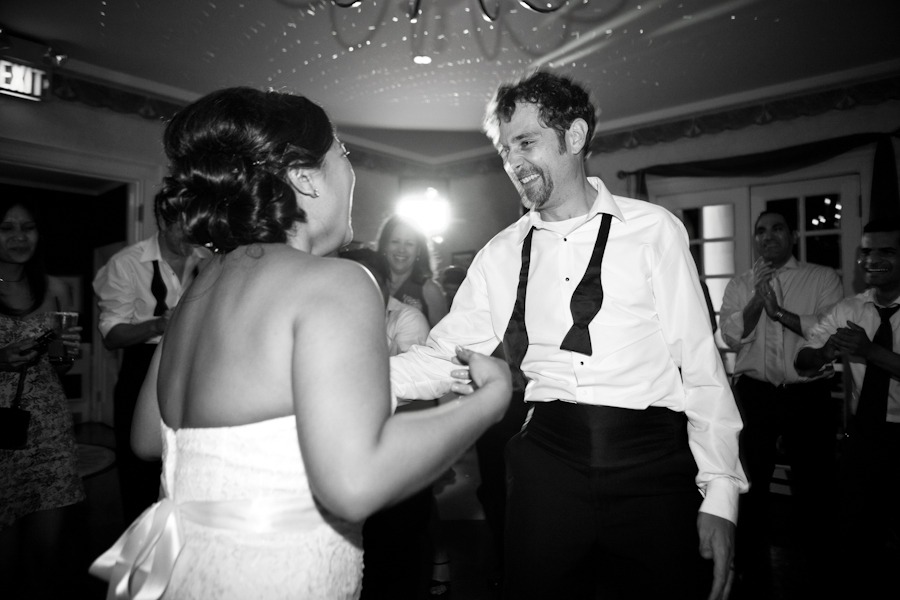 black and white of a groom dancing with his bride