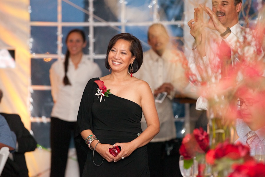 a woman in a black dress stands while smiling