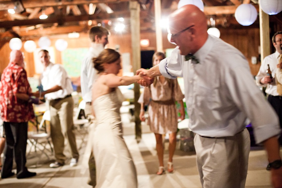 a wedding couple hold hands and spin around