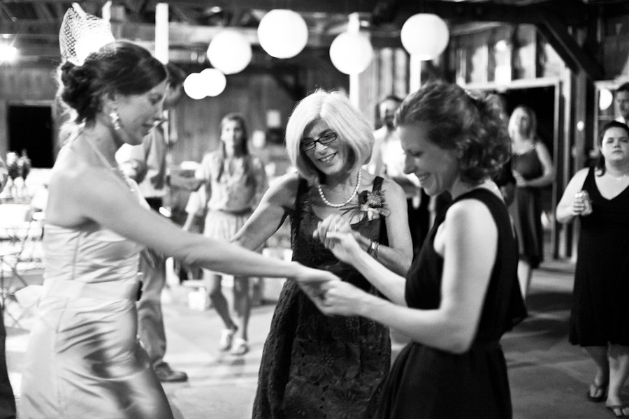 black and white photo of a bride dancing with her mom and sister