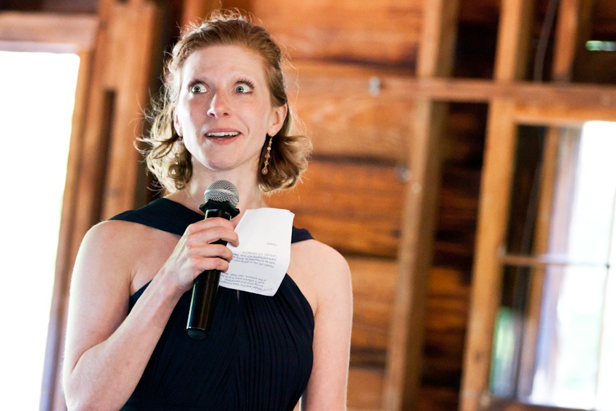 the maid of honor holds a microphone while reading a speech