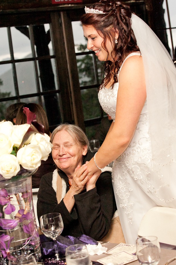 a bride puts her hand on her mother's shoulder