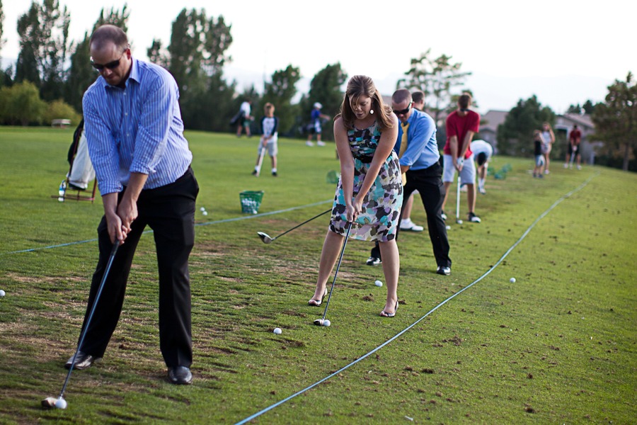 wedding guests line up at a driving range to do some golfing