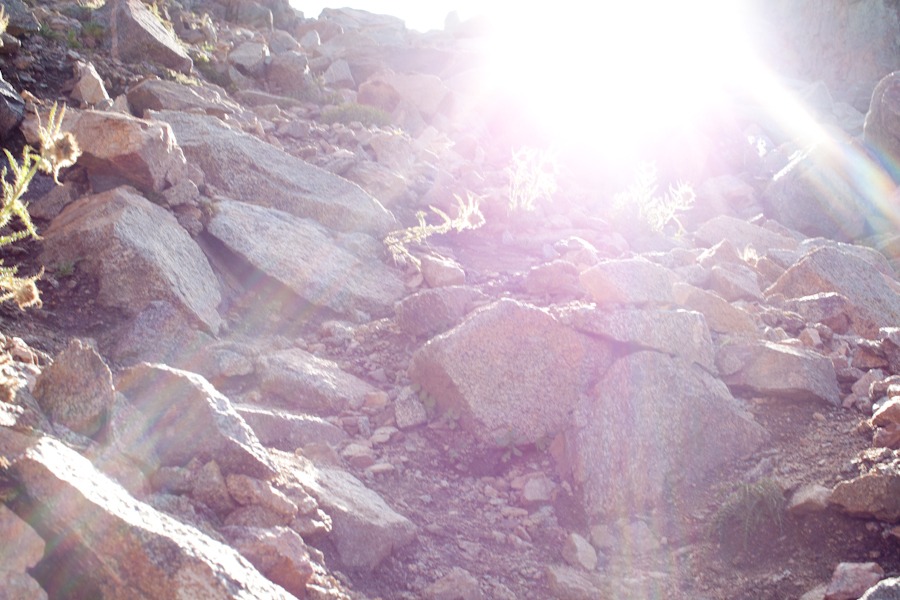 rocks and a hill and sun flare