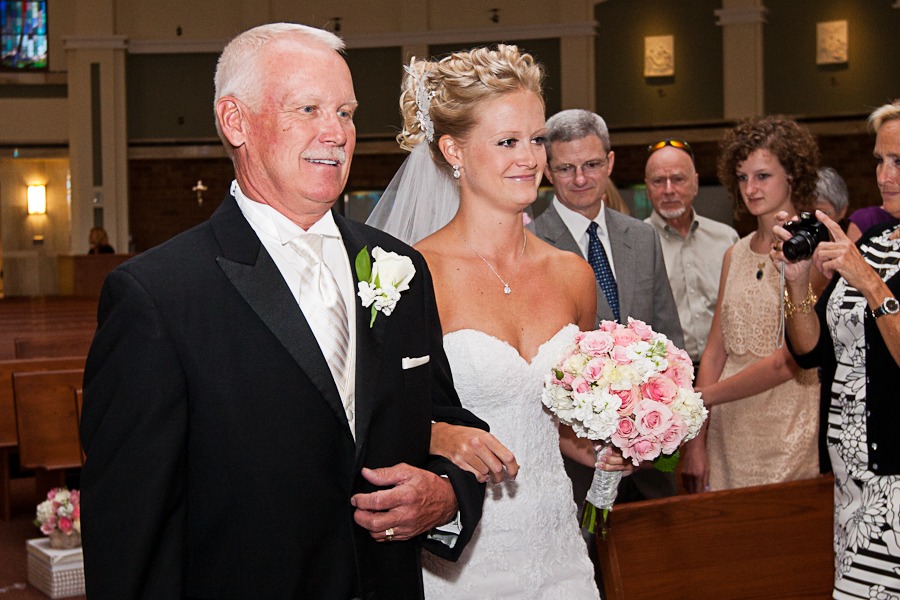 a father walks his daughter down the aisle at a church
