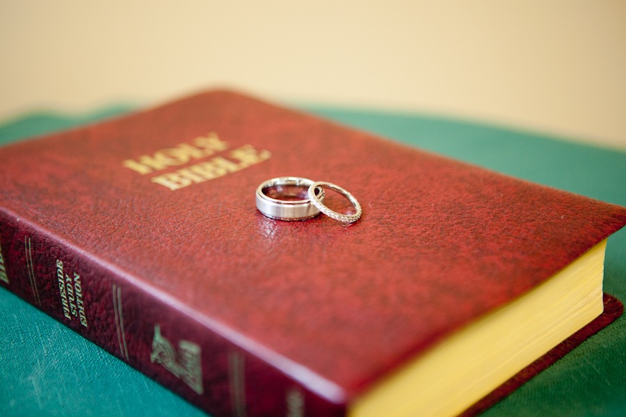 two wedding rings sit on a bible