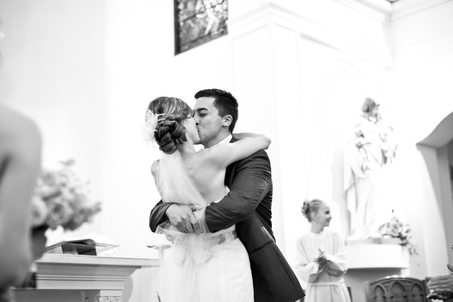 black and white photo of a kissing bride and groom