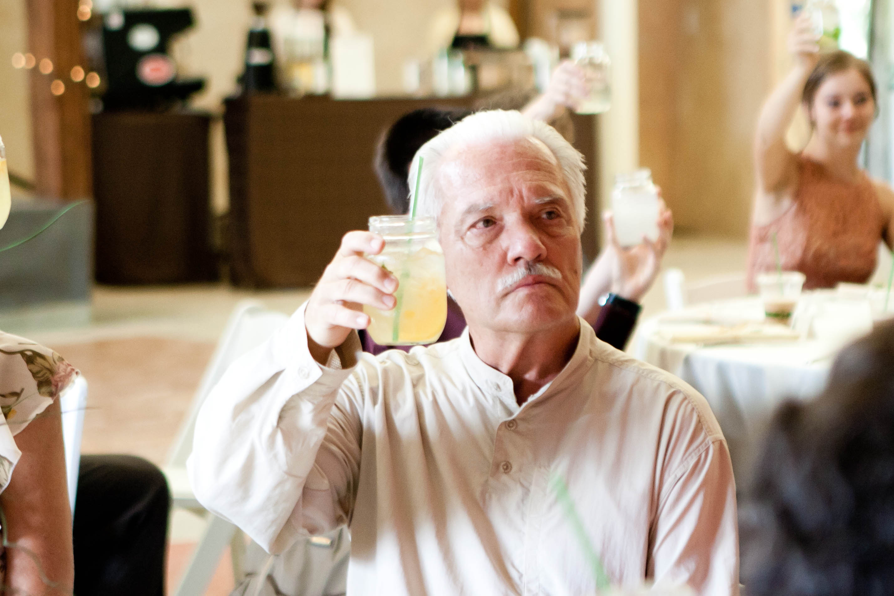 a man raises a mason glass during a toast
