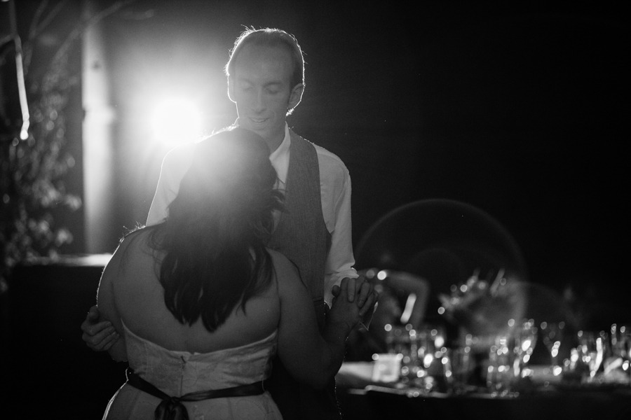black and white photo of a couple dancing in front of a light