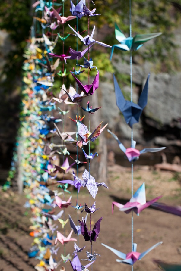 paper cranes hang from colorful strings
