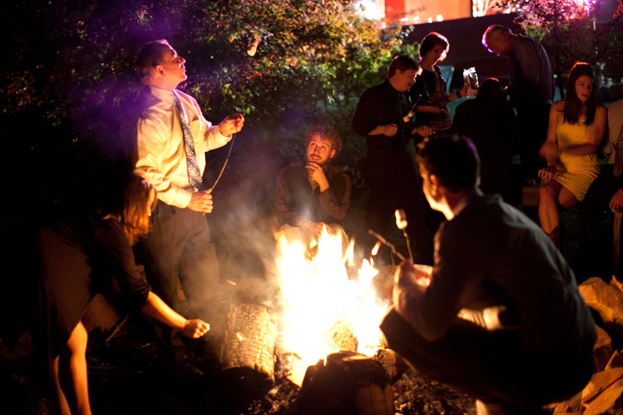 people roast marshmallows around a campfire