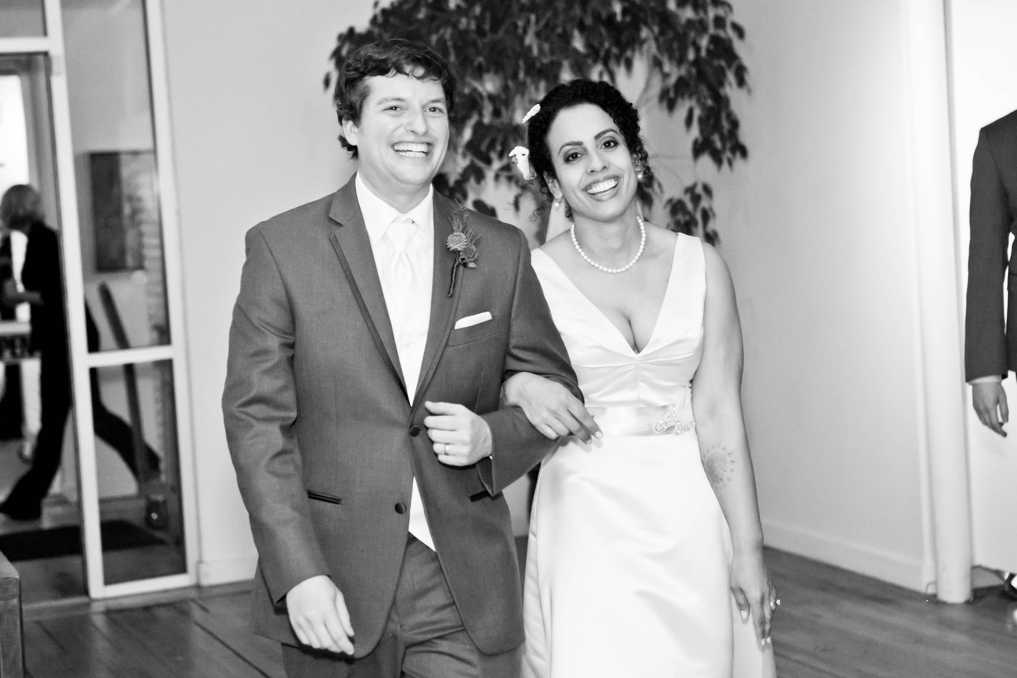 black and white photo of a happy bride and groom walking