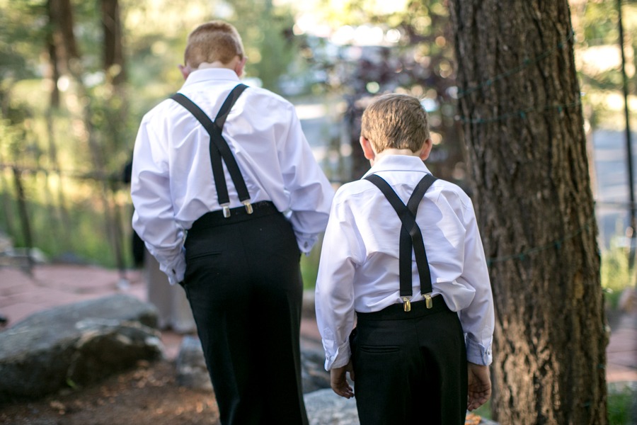 two boys face away from the camera and wear black pants and suspenders