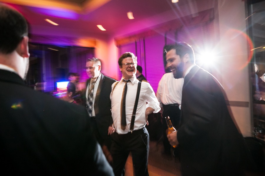 a groom in suspenders boogies down at his wedding reception