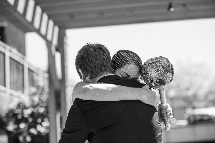 black and white photo of a bride and groom hugging after seeing each other for the first time on their wedding day