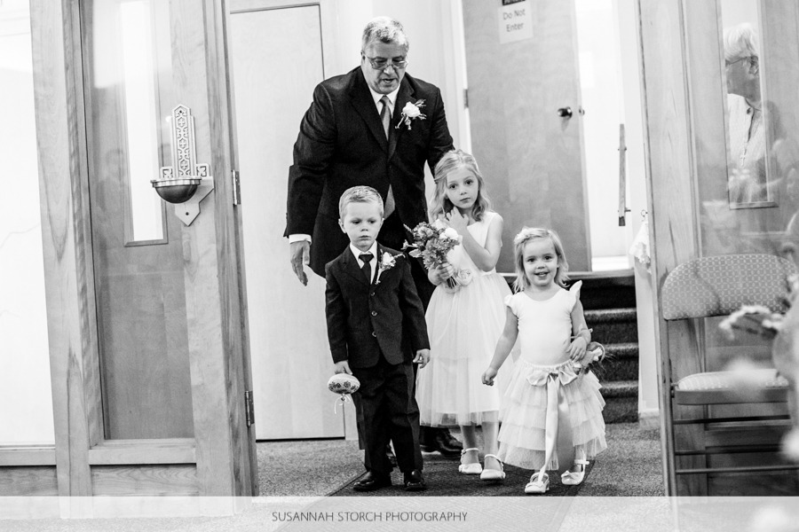 three children about to walk down the aisle at a church wedding