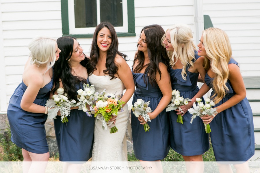 a bride looks at the camera while her bridesmaids look at her
