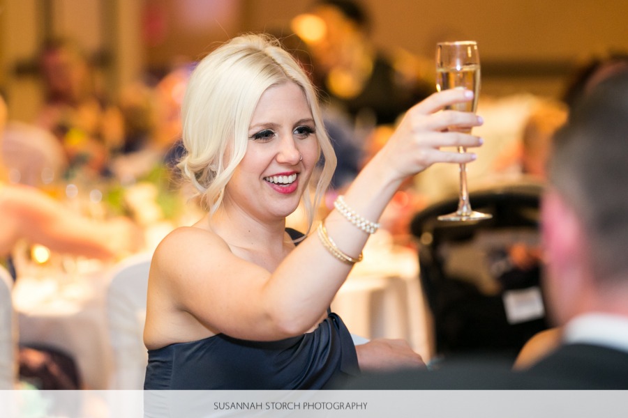 blonde woman raises a champagne glass in a toast