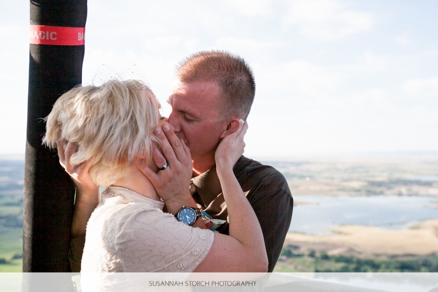 a man and woman kiss while getting married in a hot air balloon