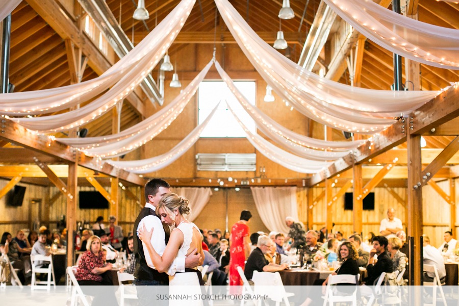 wedding couple dance in front of a room of round tables