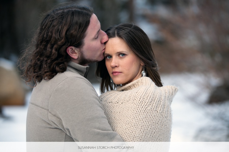 a man with long hair kisses a blue-eyed woman