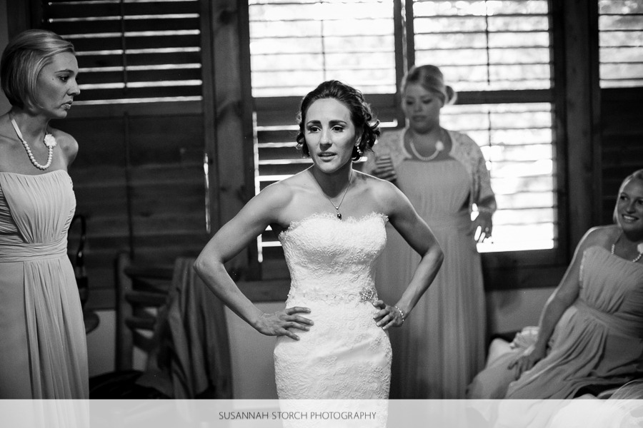 a bride in a beautiful slim gown stands with her hands on her hips