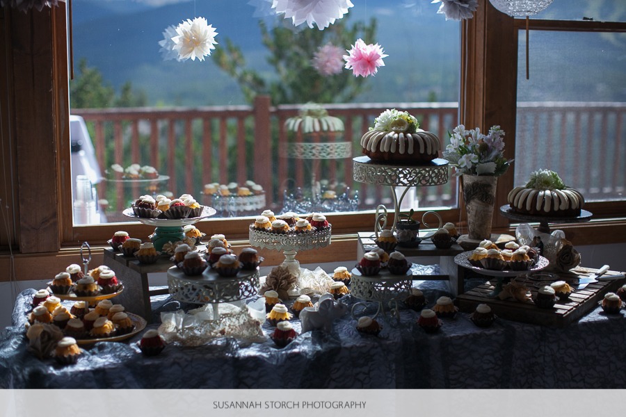 a dessert table sits in front of a mountain window