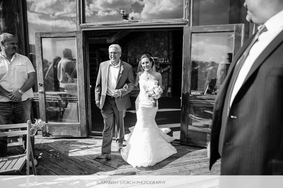a father walks his brunette bride down the aisle at an outdoor wedding