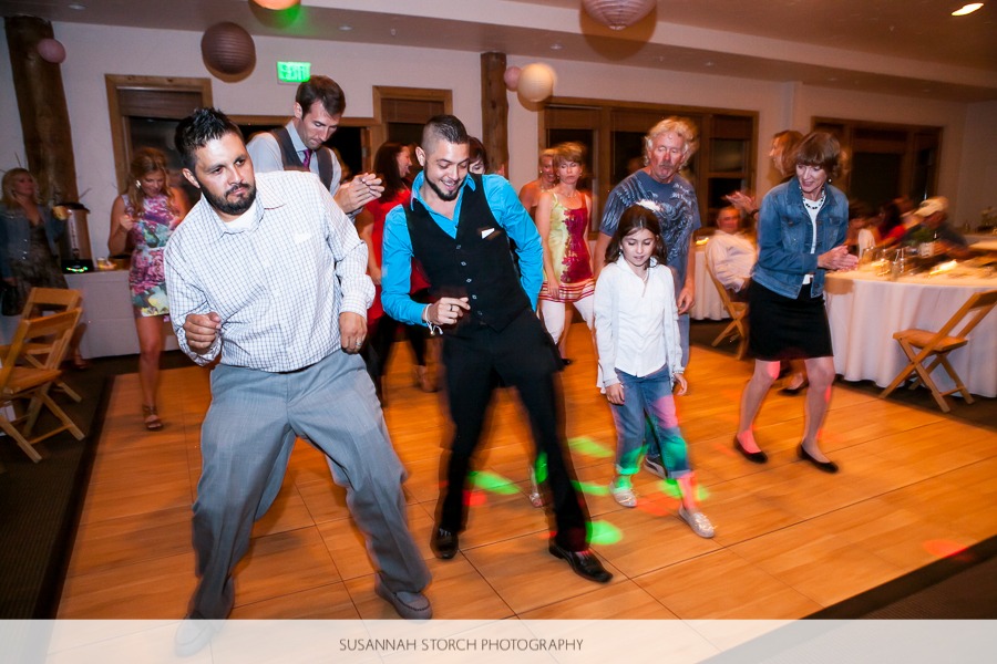 wedding guests squeeze in on a dance floor to do a line dance