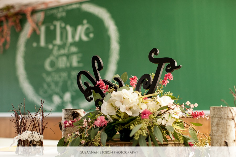 flowers and intials decorate a table in front of a green chalkboard