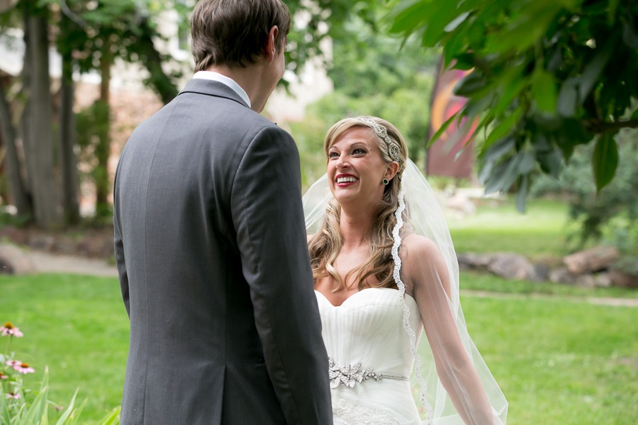 an excited bride gazes up at her soon-to-be husband who is wearing a gray suit
