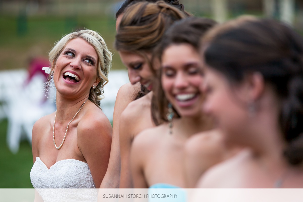 a beautiful bride tilts her head back in a laugh while hanging out with her bridesmaids