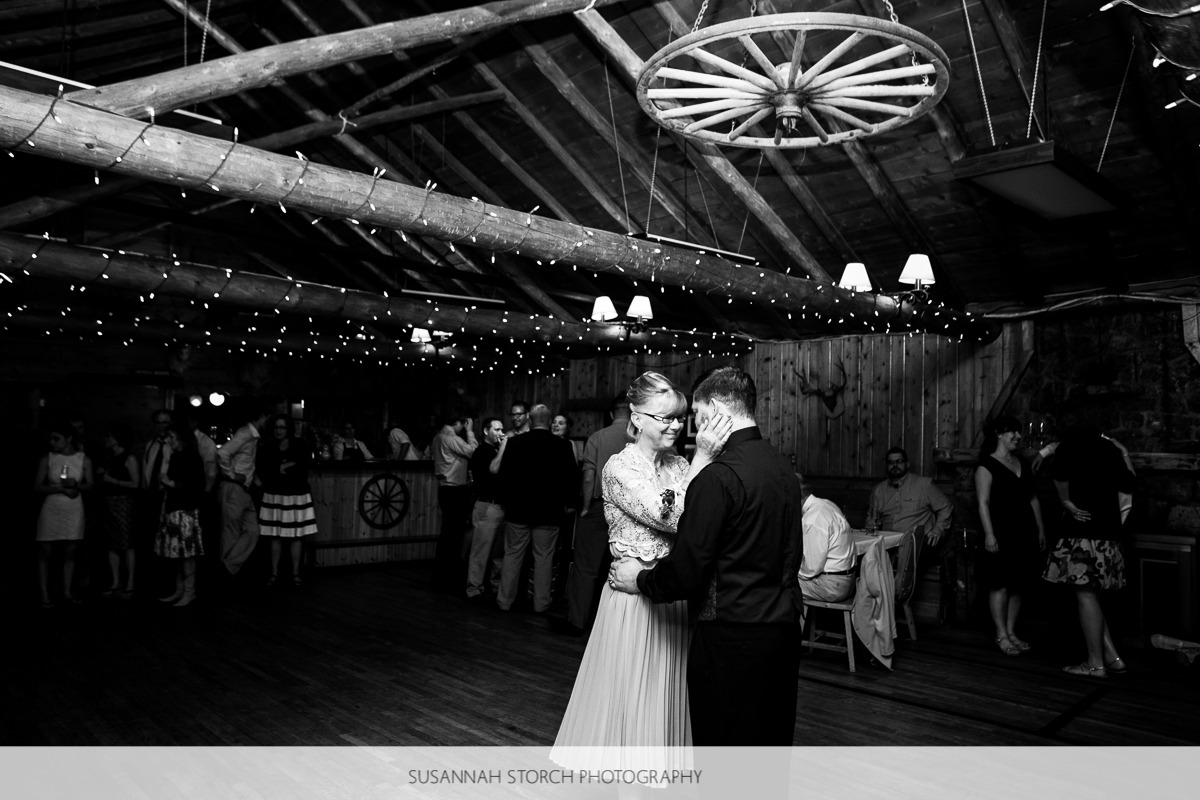 black and white photo of a groom's mom holding his head while dancing