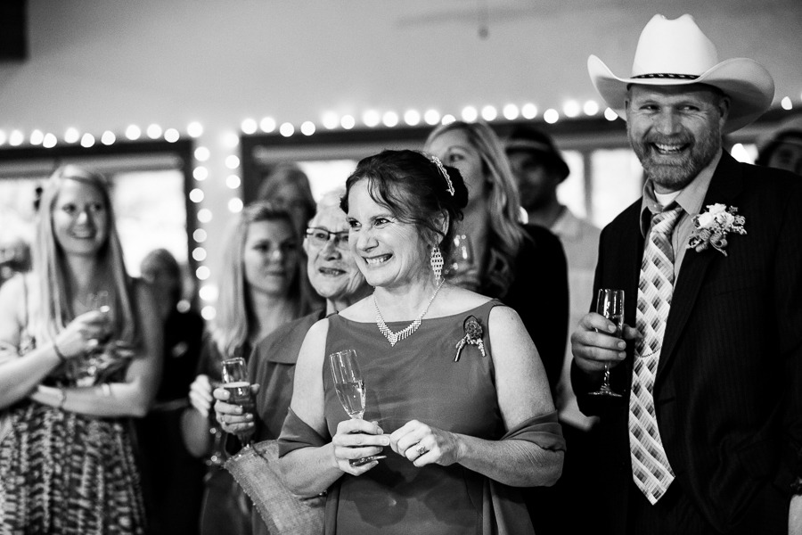 black and white photo of smiling wedding guests holding glasses of champagne