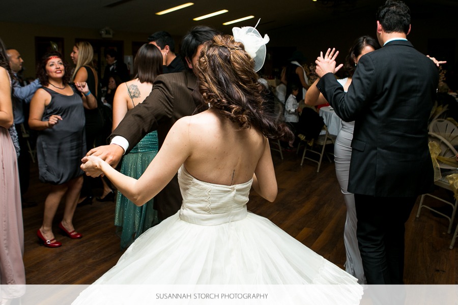 a bride spins around on the dance floor, flaring her skirt