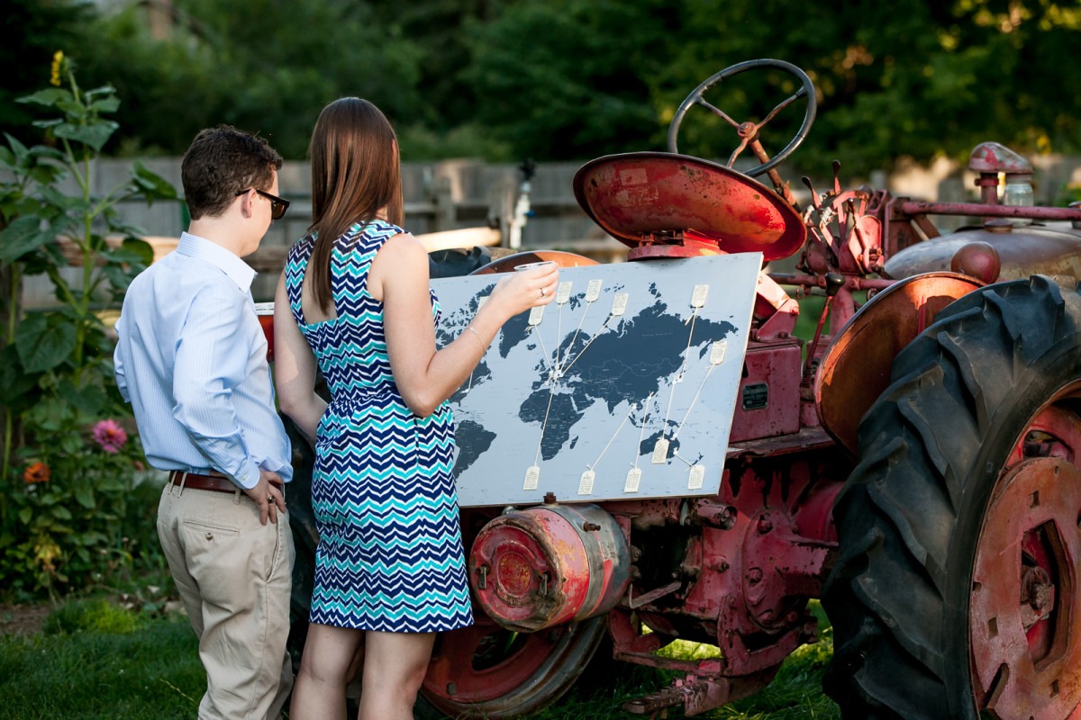 a man and woman look at a map sitting on a red tractor