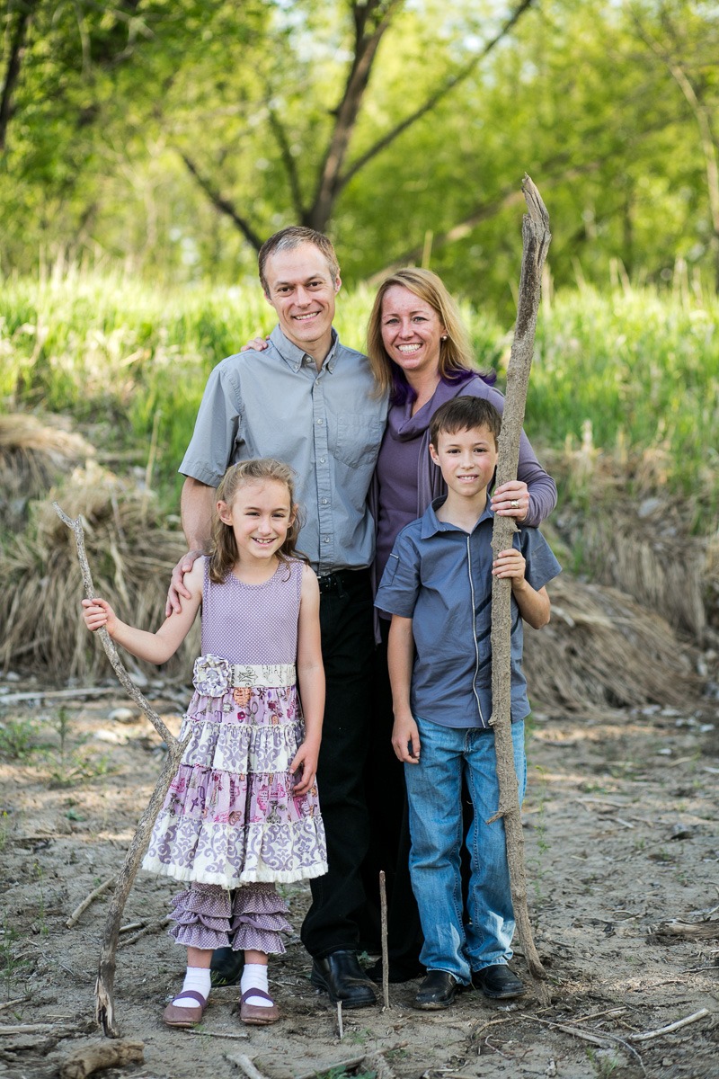 a family of four poses with sticks