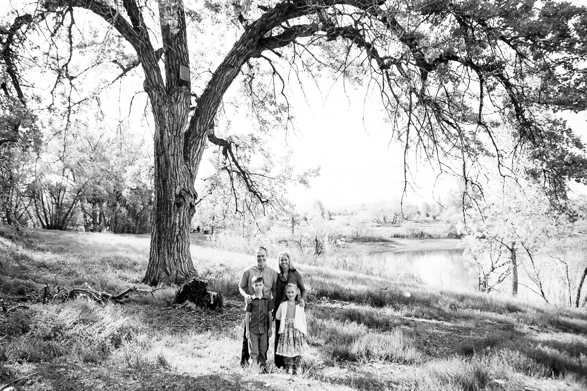 black and white image of a family under a big tree