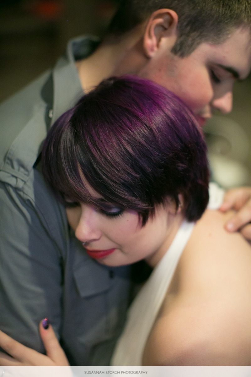 woman with purple hair leans into a man
