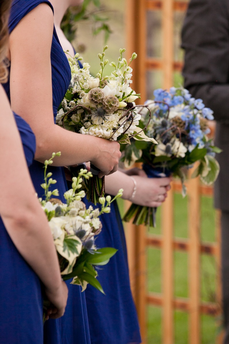 bridesmaids in royal blue hold white bouquets