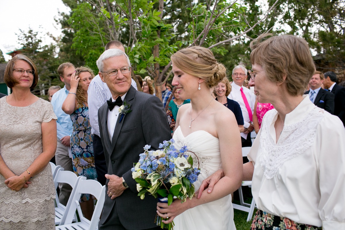 parents walk down the aisle of an outdoor wedding ceremony