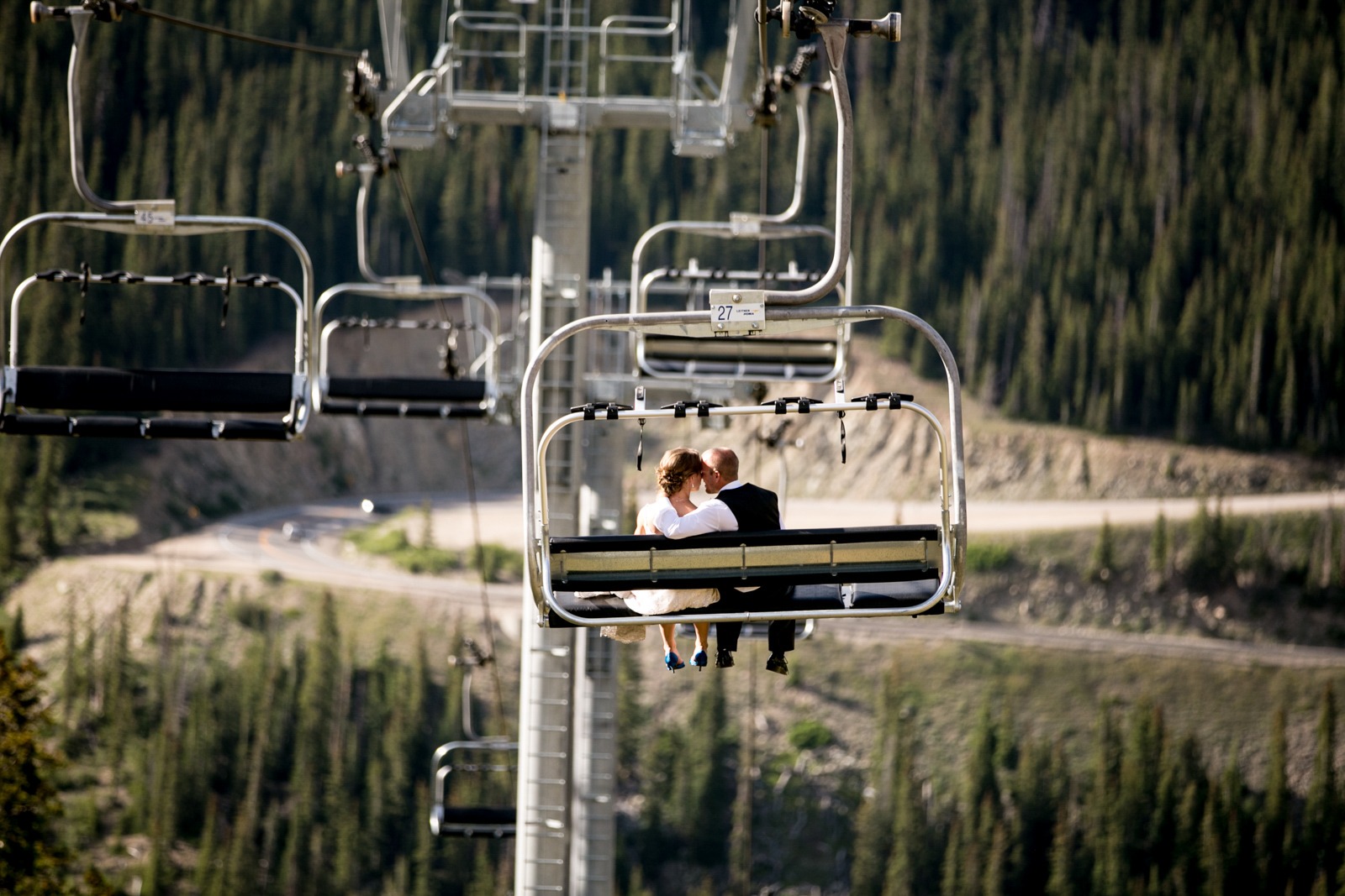 man and woman snuggle on a ski lift