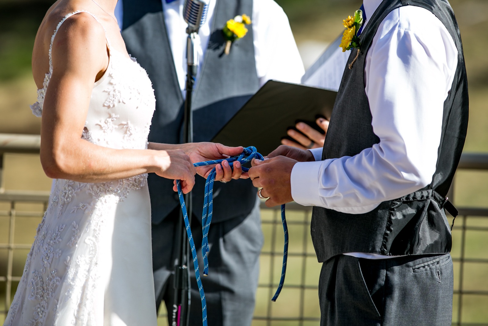 the ands of a bride and groom as they tie knots in blue rope