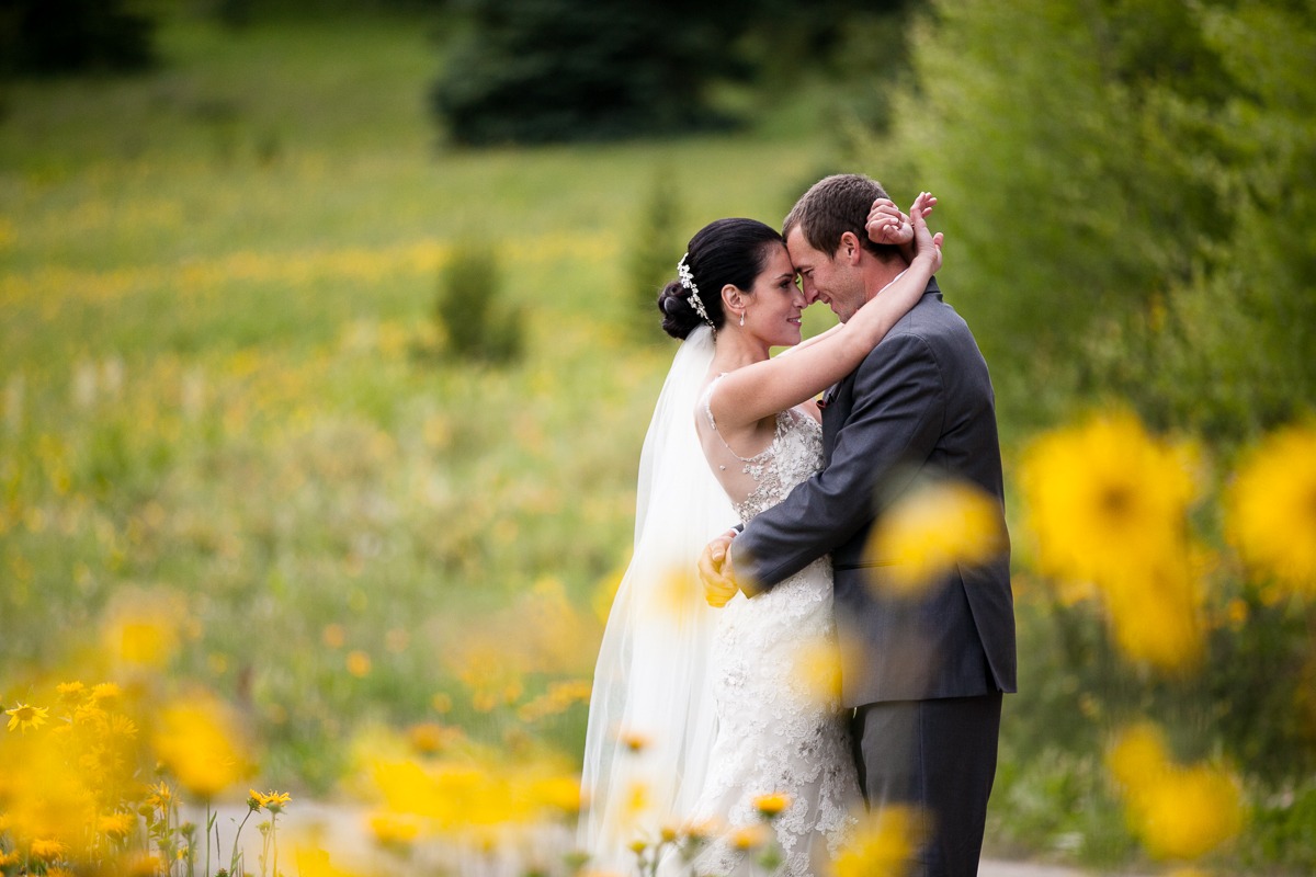 bride and groom hug among yellow flowers