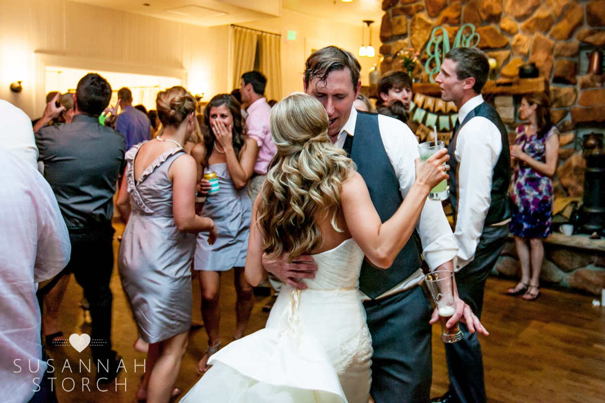 bride and groom dance while holds beverages